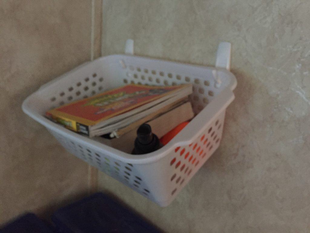RV storage idea - a basket hanging from command hooks is a great RV organization hack that doesn't require tools. You just adhere the command hooks to your wall (and yes they do hold well)