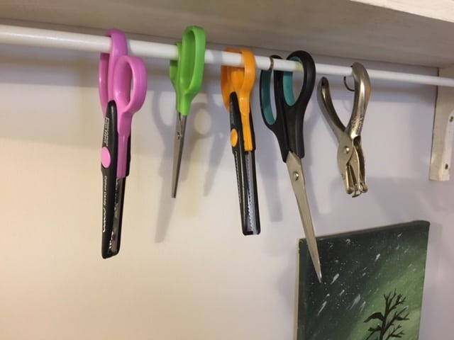 Tension rod holding up scissors