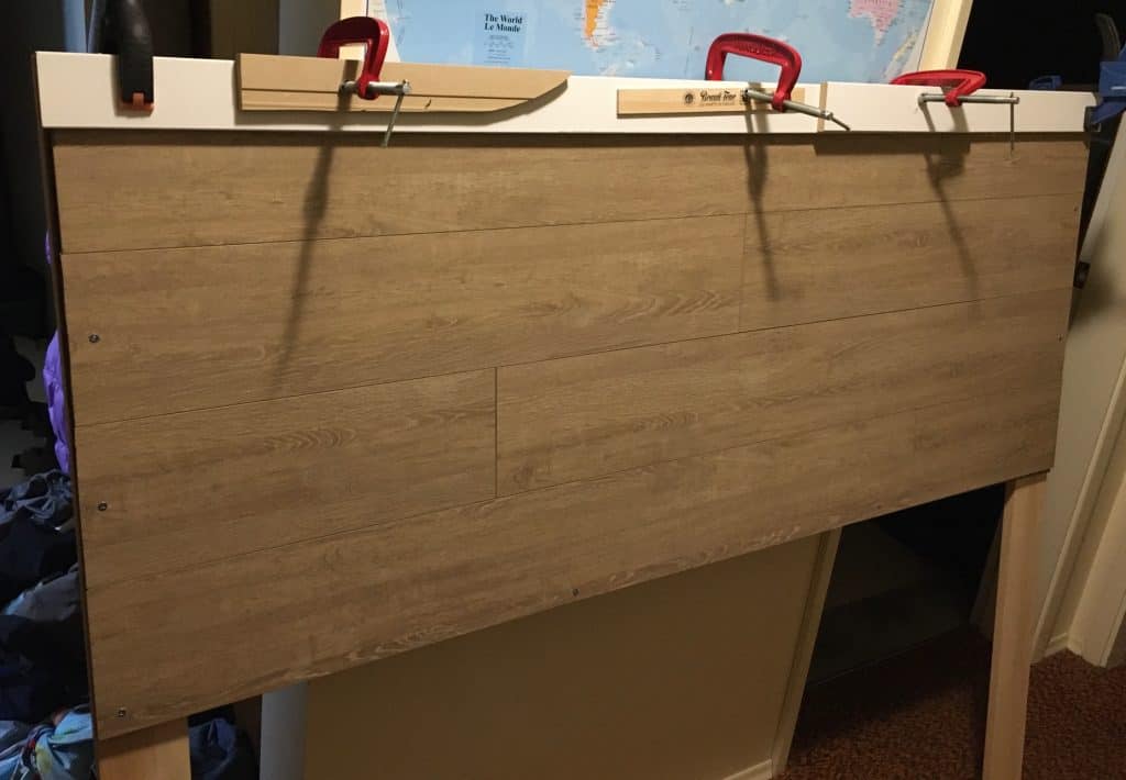 Cheap DIY headboard with laminate flooring - gluing the trim into place