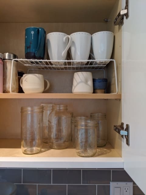 Small kitchen organization ideas. Dish risers or wire racks like this allow you to store cups and mugs above other smaller glasses or mugs.