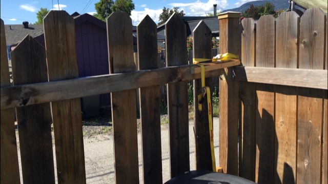 Replacing rotten fence posts - in this before picture I was using ratchet straps and scrap wood to keep the fence together.