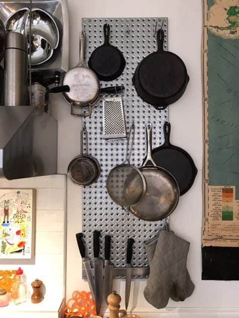 Small kitchen organization ideas - Pegbaords and "S" hooks to hang pots and pans.