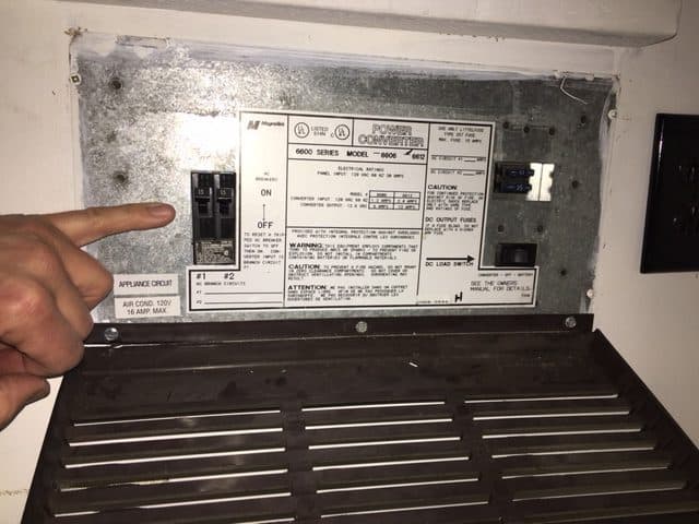 The electrical converter in my 1997 Palomino Colt pop up camper. I'm pointing to the A/C breakers.