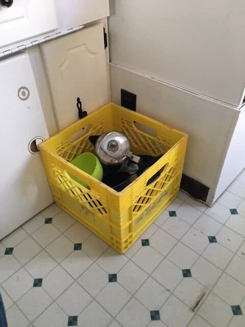 Plastic milk crates are convenient and a handy pop up camper storage idea