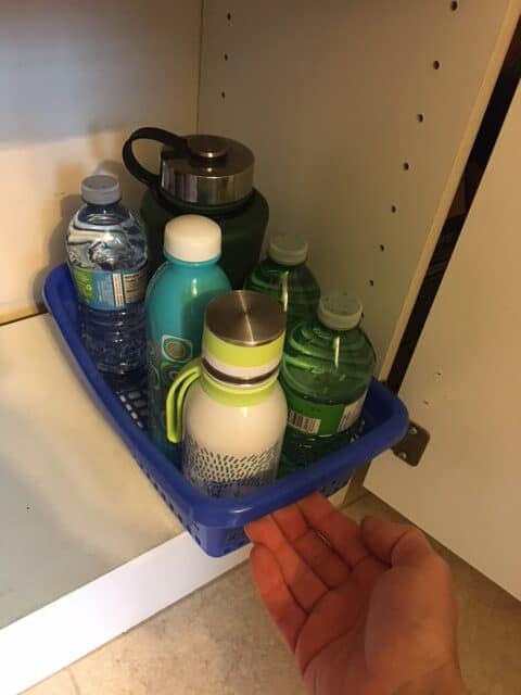 a plastic container works as a simple water bottle storage option