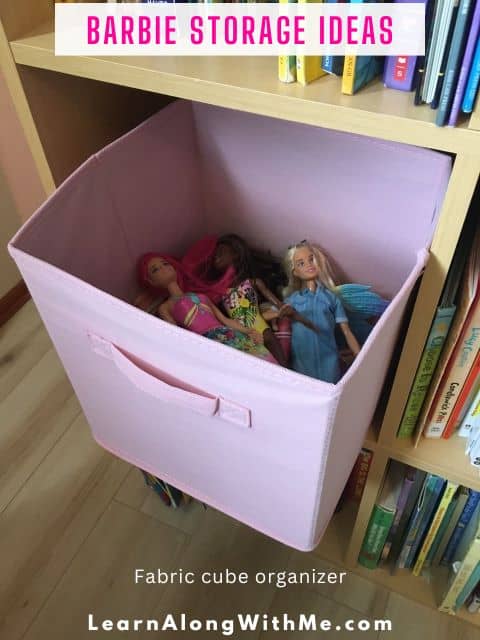 Barbies stored in a fabric cube organizer on a cube shelving system among kids books