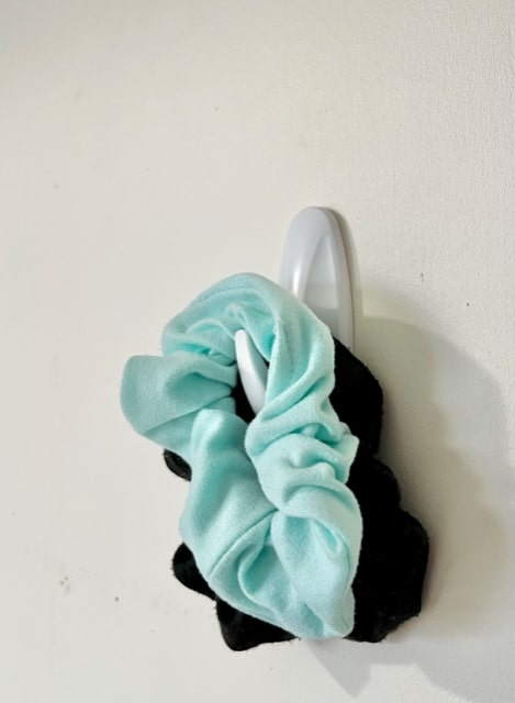 Scrunchie storage ideas - place your scrunchies on a command hook to hold them. A standard command hook may only hold one or two scrunchies but you could put up additional hooks for more storage.