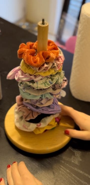 A wooden countertop paper towel holder can work well to hold scrunchies too