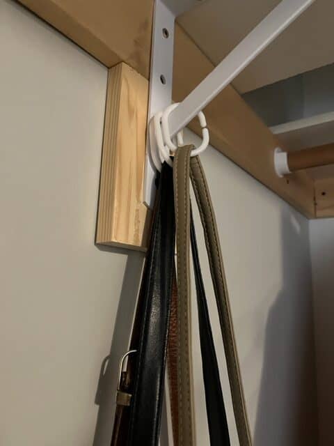 hanging purses from a shelving bracket using plastic shower curtain rings