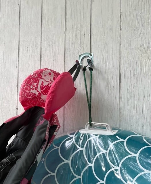 Double hooks mounted to a wall or fence can work well to hold pool floats